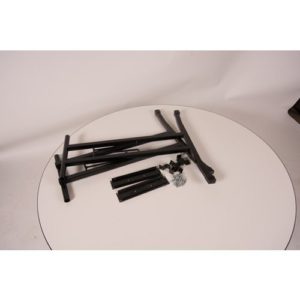 Pair of black metal T shape legs with plates, saddles and screws on top of a round, white maline table top