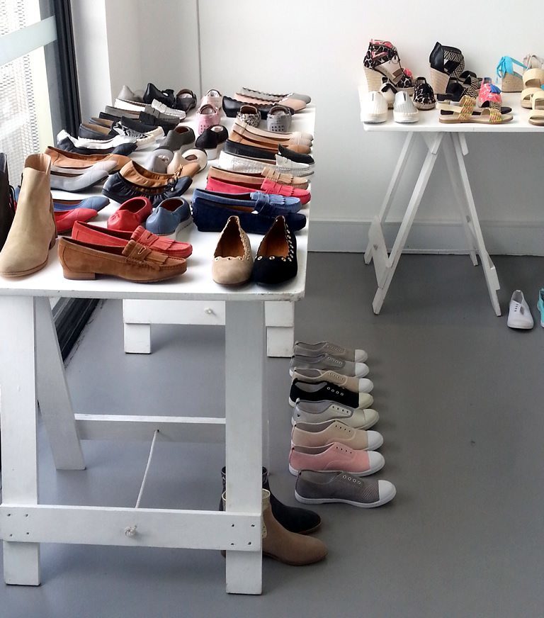 White painted trestle table with various shoes on top