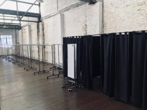 Clothing racks and change rooms and mirrors used for a clothing sale